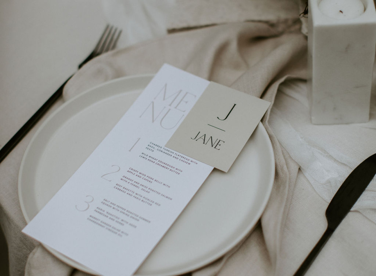 An elegant, minimalist table setting with a menu and place card at The French Cafe in Auckland, a refined French-inspired venue.