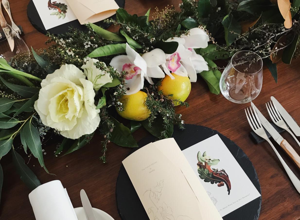 The French Cafe, Auckland, presents an elegant table setting with fresh florals and custom menus, reflecting its sophisticated dining style.