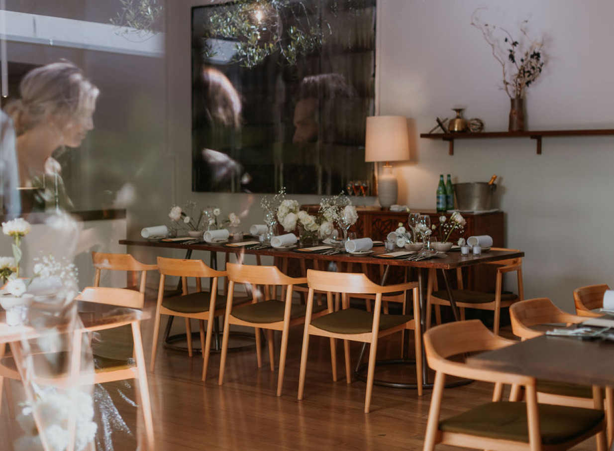 The French Cafe in Auckland offers an elegant private dining room with polished timber floors, impeccably set for an event.