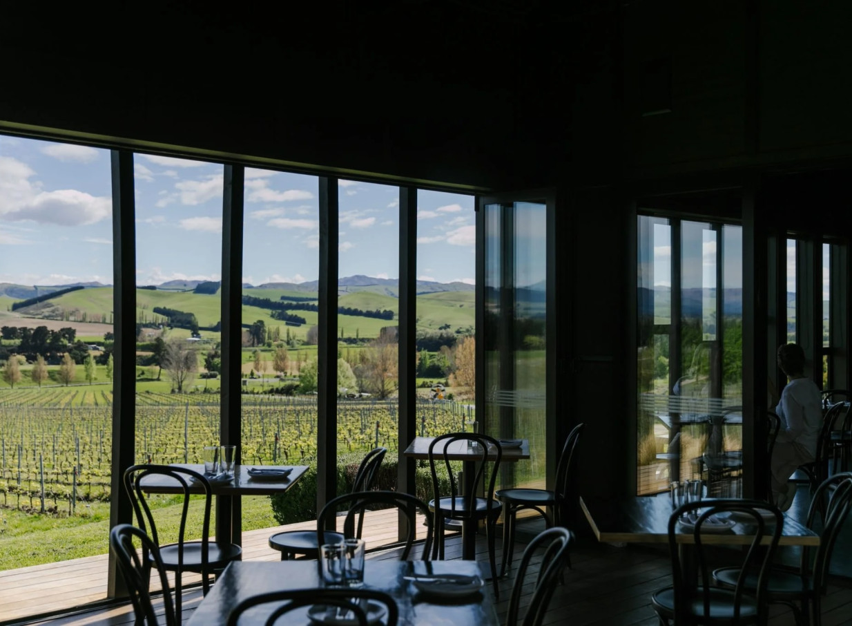 This modern, shed-like dining room at Black Estate Winery in Waipara Valley offers expansive views of the vineyard and rolling hills.