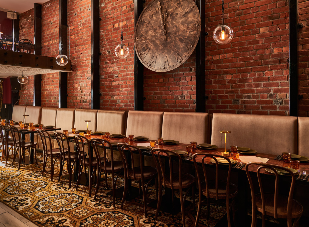A long communal table in The Monday Room, Christchurch, features an industrial-chic dining room with exposed brick walls.