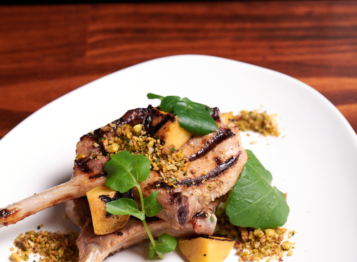 Grilled pork chops with pistachio and fruit, a contemporary European dish from Christchurch's historic The Monday Room.