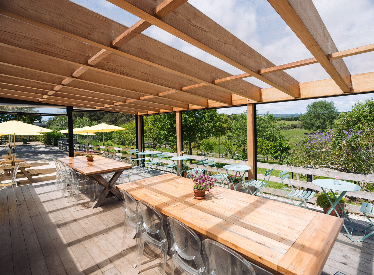 The Farm House Cafe in Auckland features a rustic-chic outdoor dining patio with wooden pergolas and views of the Clevedon countryside.