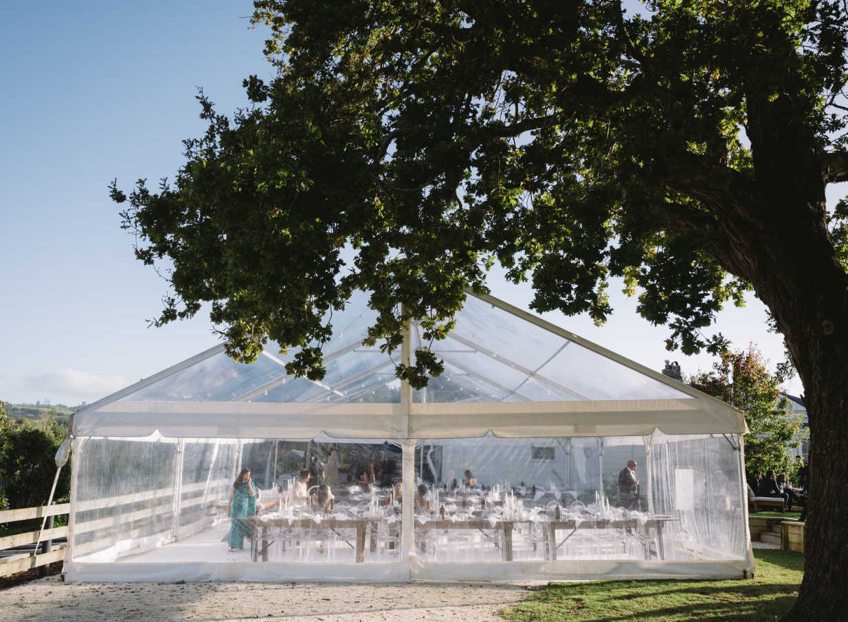 Guests dining in a clear marquee at the charming rural Farm House Cafe in Auckland.