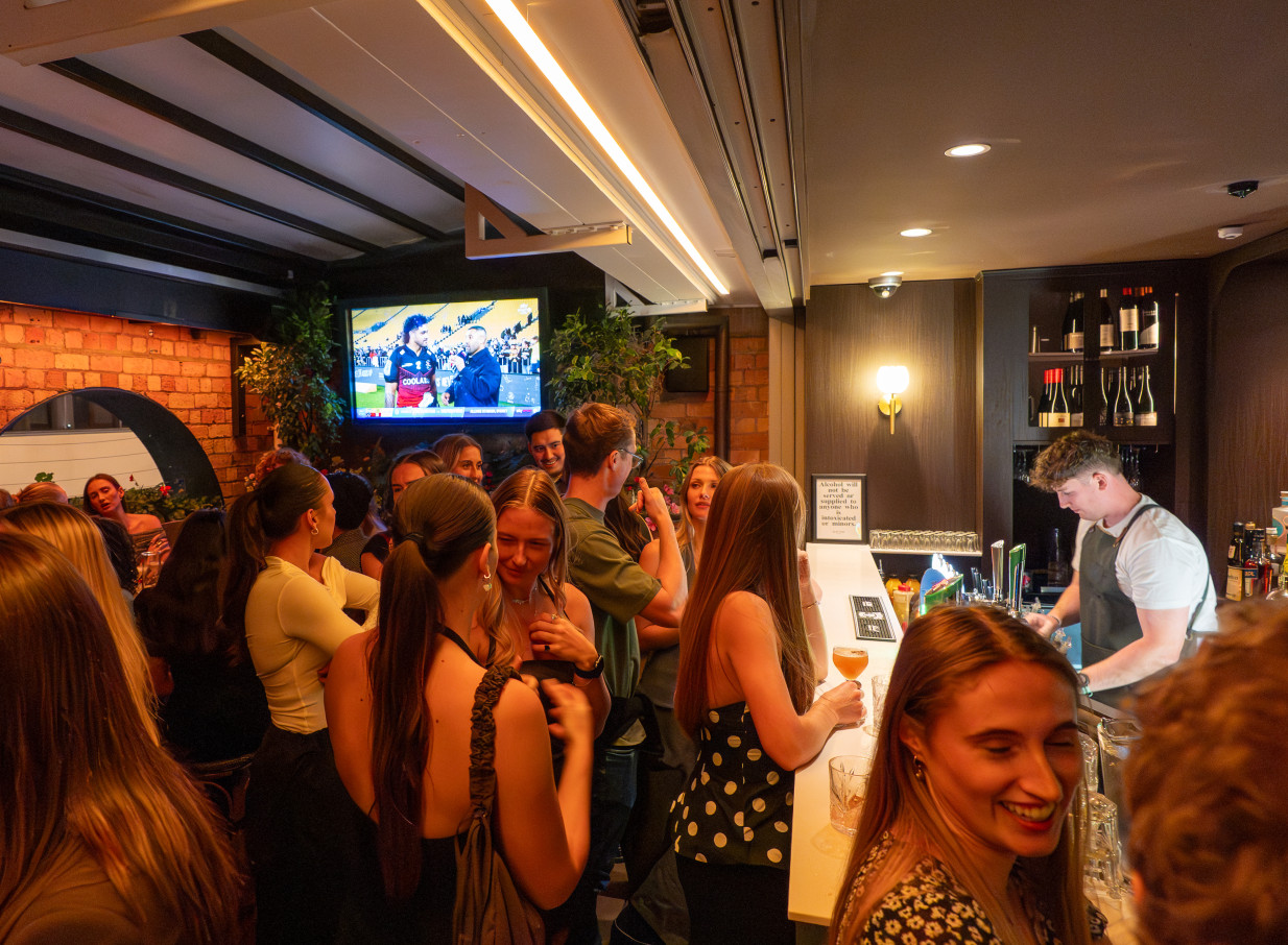 Patrons enjoy drinks at the lively bar of Slattery & Sons, a modern Irish pub in Auckland.