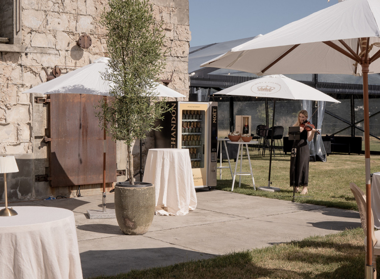 An outdoor event at The Flaxmill, Christchurch, showcases its industrial-chic architecture with live violin music.