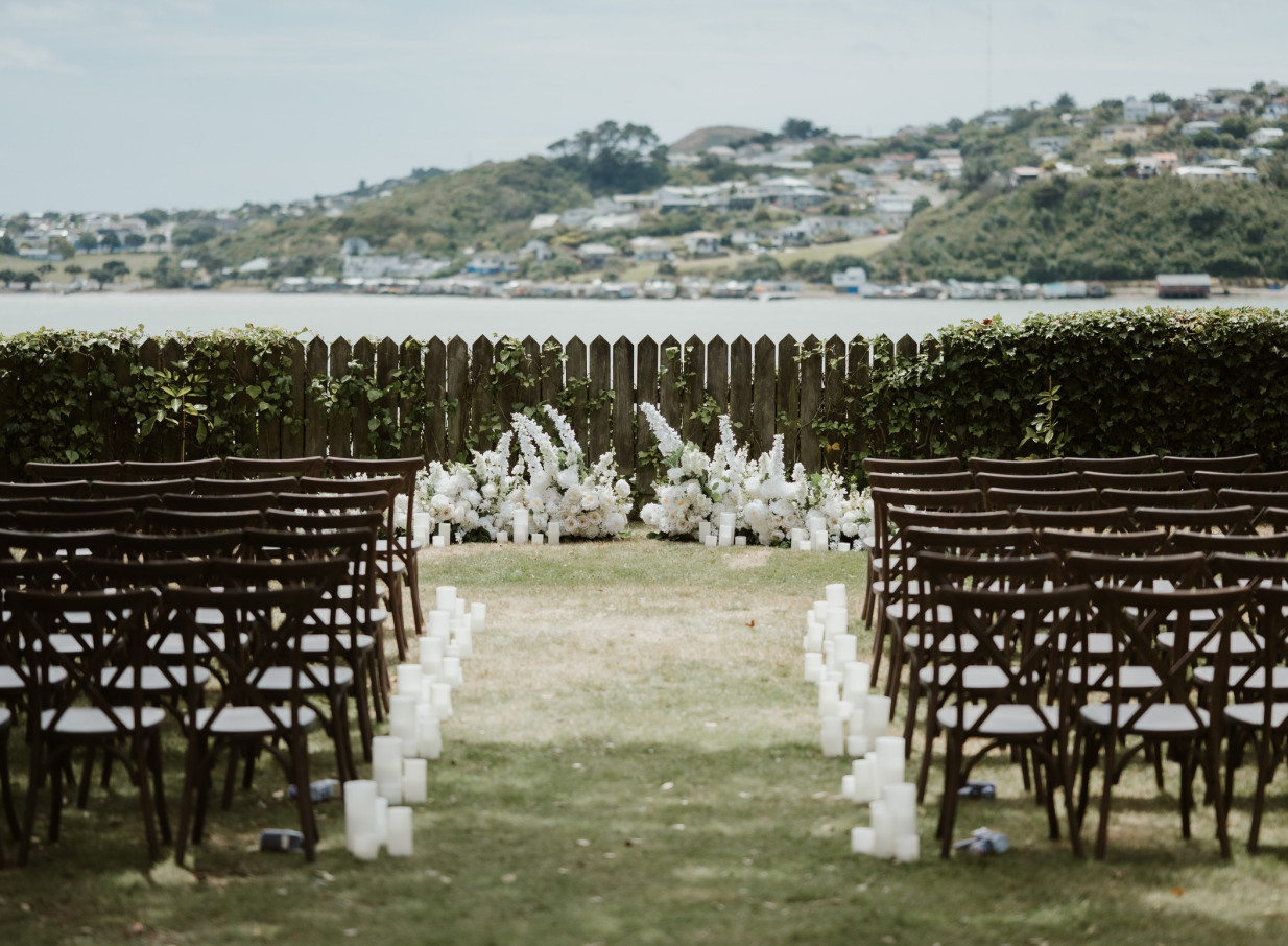 An outdoor wedding ceremony setup in the heritage gardens of Gear Homestead, Wellington, with scenic water views.