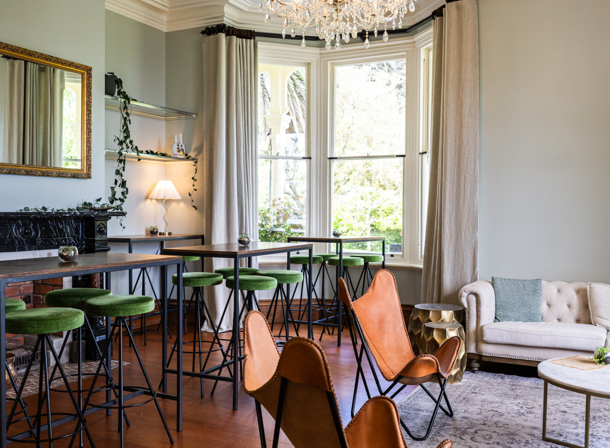 Gear Homestead's charming Victorian cocktail lounge in Wellington features green velvet bar stools and elegant bay windows.