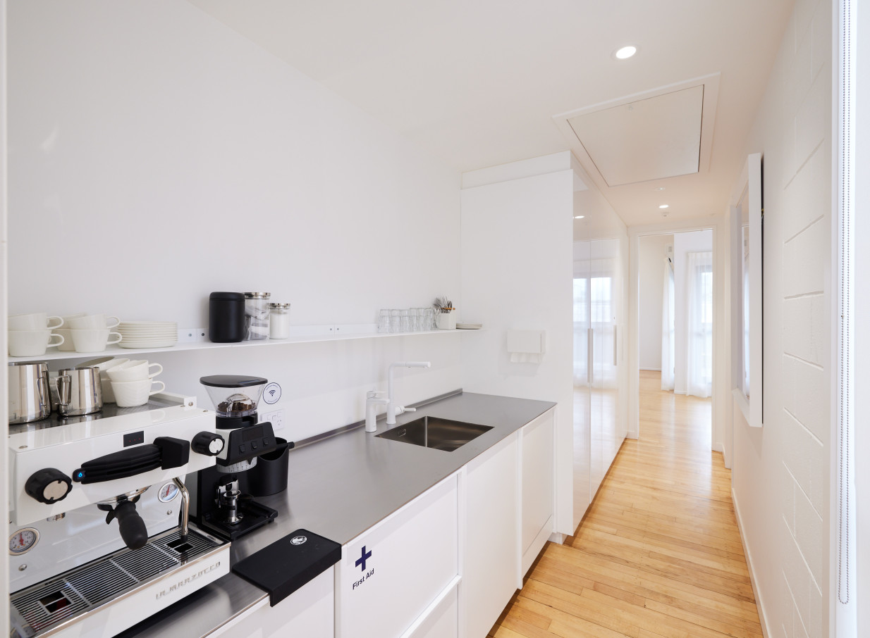 A modern, bright kitchenette with a professional espresso machine at Common Space Studios, Auckland.