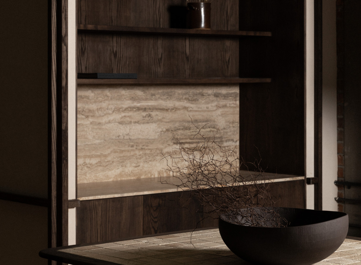 A modern, design-led interior display within Casa Bella, Auckland, highlights dark wood shelving and natural stone textures.