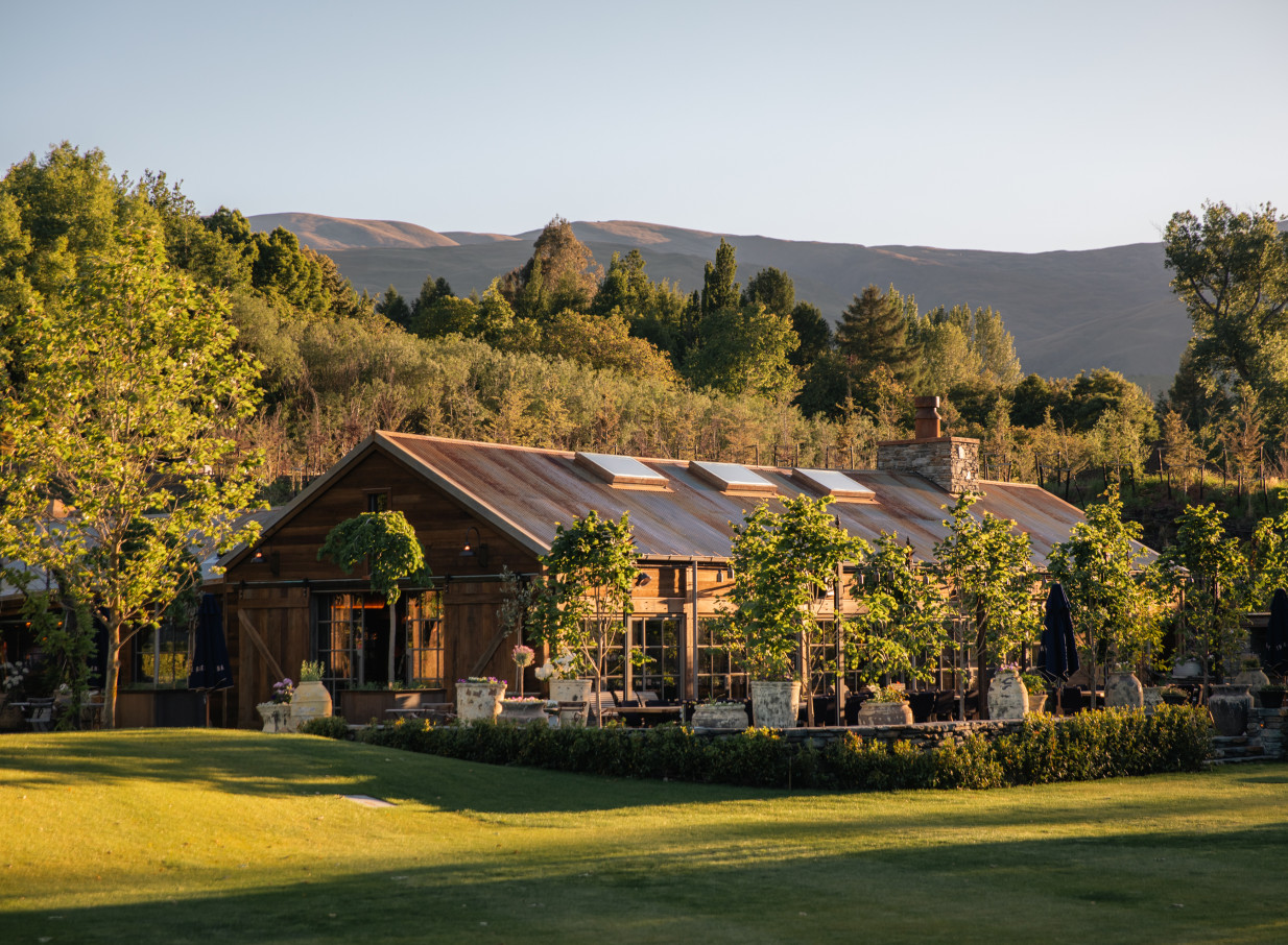 An inviting outdoor dining space at Ayrburn in Queenstown, a reimagined heritage farm building blending rustic charm with modern elegance.