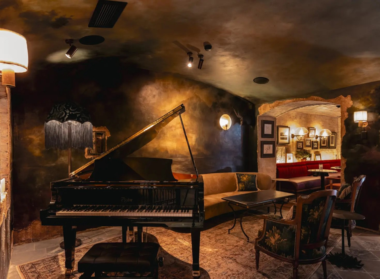 A heritage-inspired lounge with a grand piano and plush seating at Ayrburn, Queenstown's reimagined farm estate.