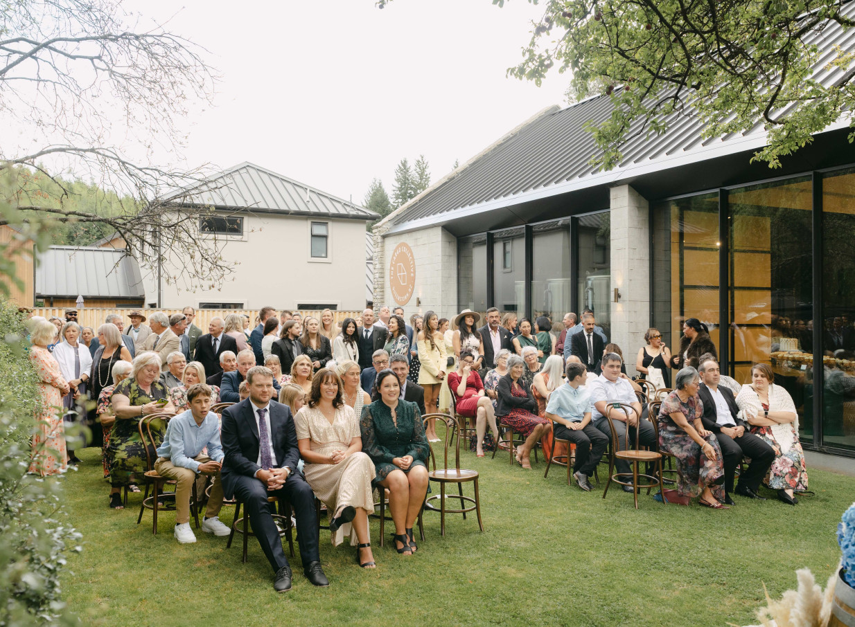 Outdoor ceremony at The Cargo Collective Brew Hall, Queenstown, a modern venue with stone and glass elements.