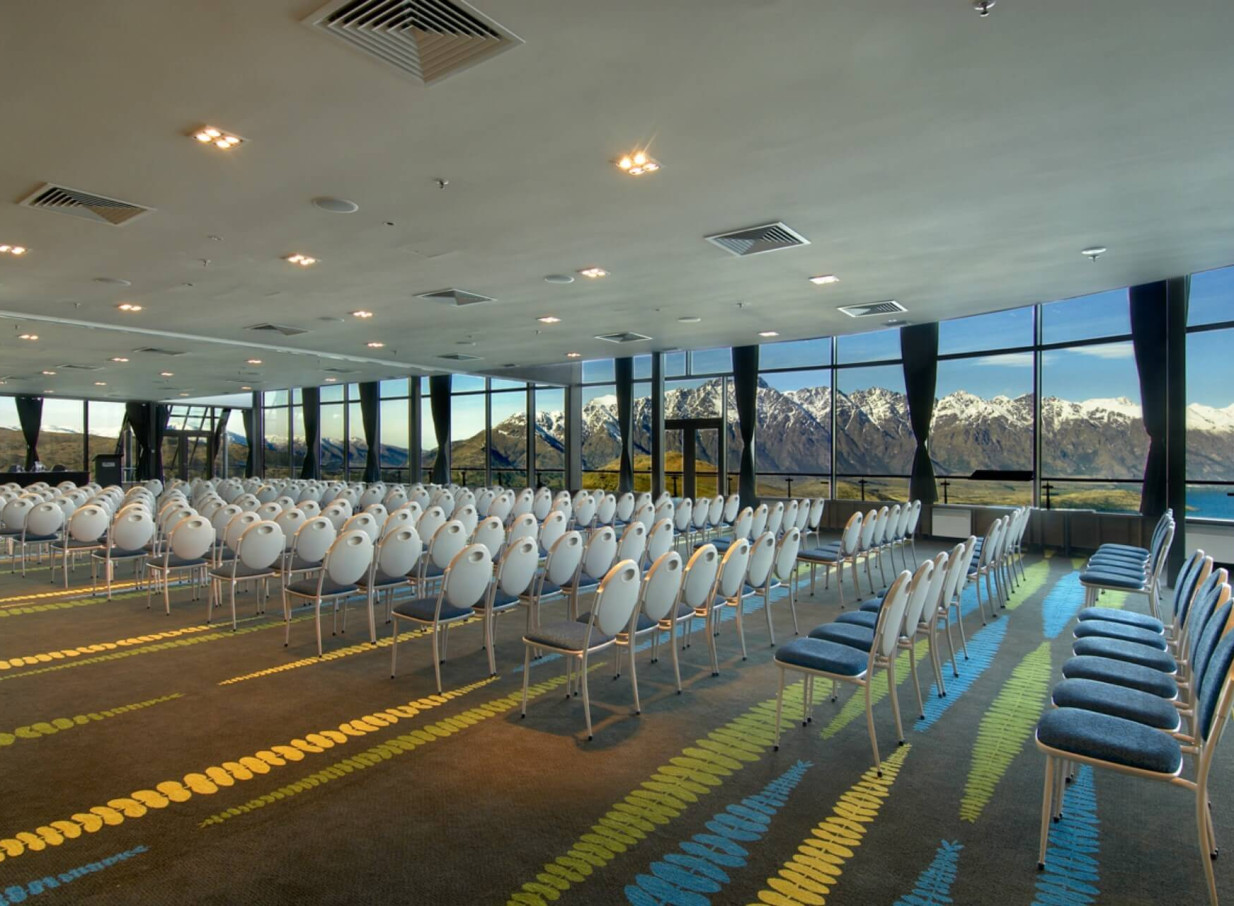 Skyline Queenstown's conference room with theatre seating offers panoramic mountain and lake views through expansive windows.