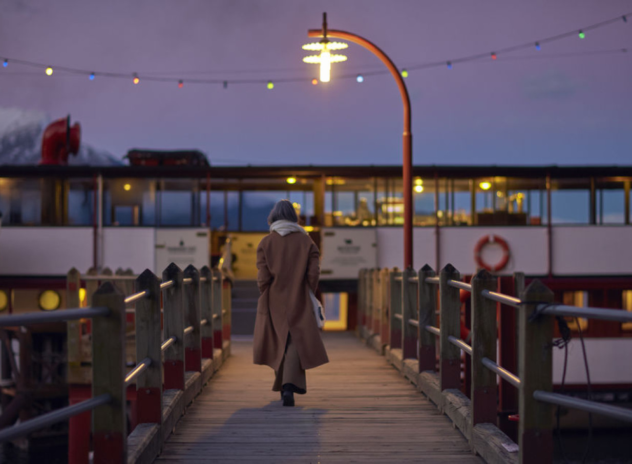 A person boards the illuminated historic 1912 Edwardian twin-screw steamship TSS Earnslaw in Queenstown.
