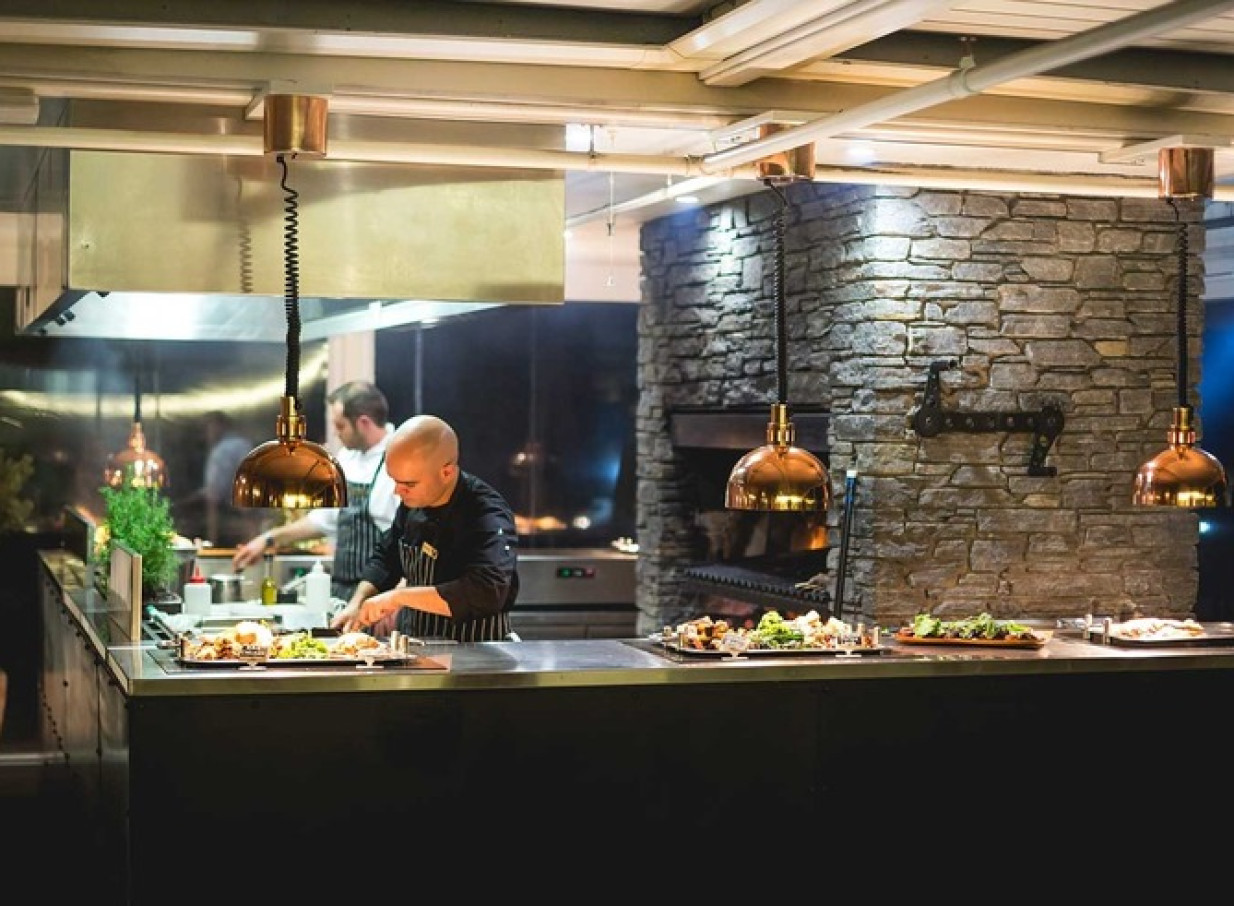 A chef prepares dishes at the gourmet BBQ buffet inside Walter Peak's historic Colonel's Homestead Restaurant in Queenstown.