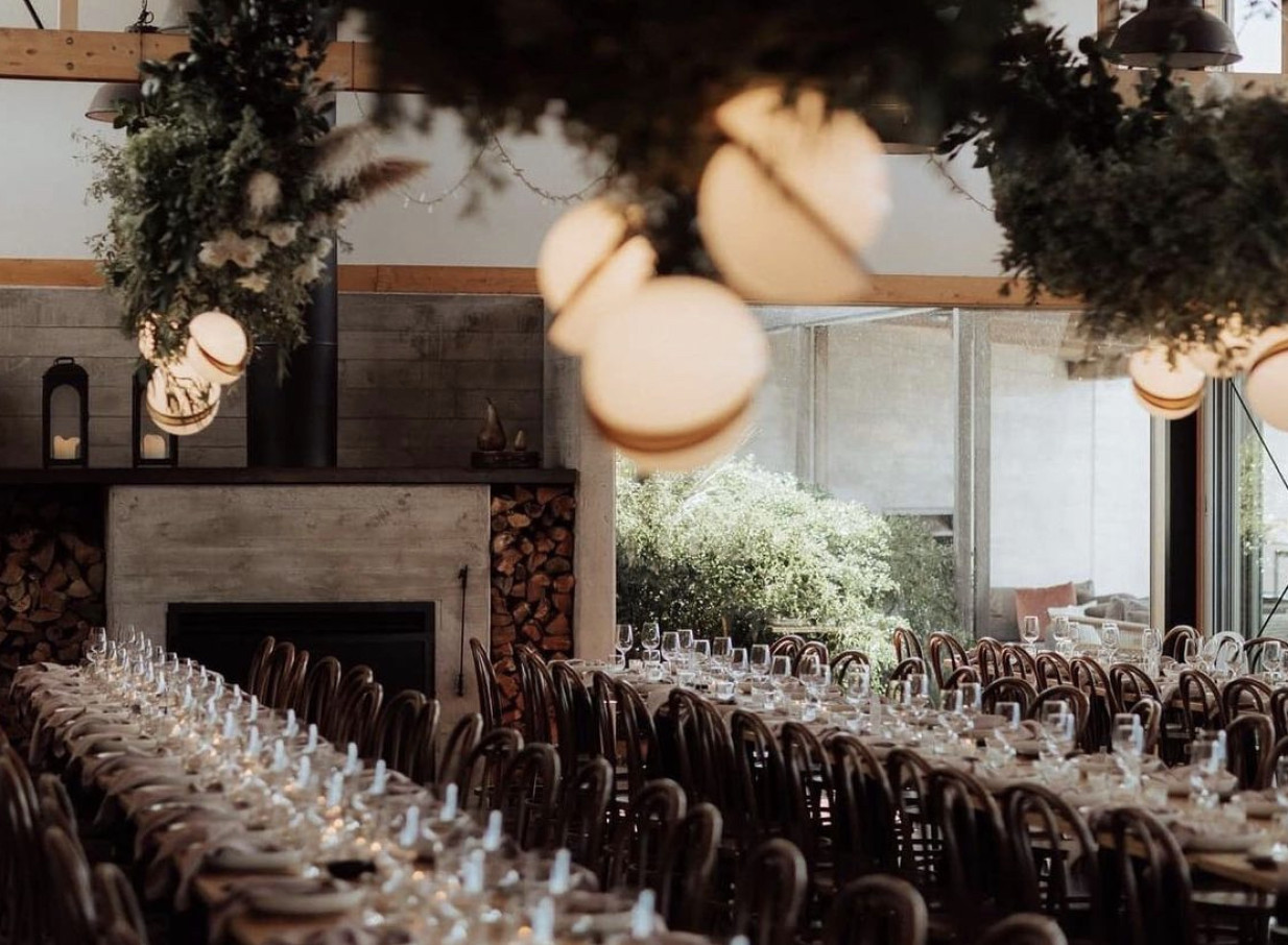 Kauri Bay's modern rustic dining room in Auckland, beautifully set for an elegant event with a natural backdrop.