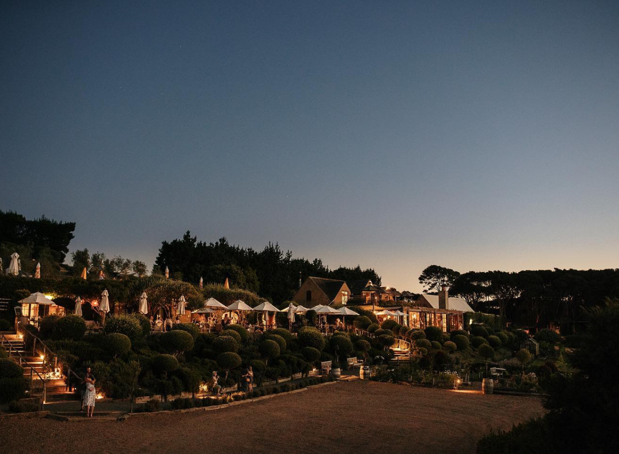 Mudbrick on Waiheke Island showcases its Tuscan-inspired outdoor dining and lush gardens illuminated at night.