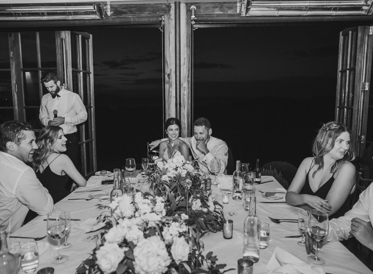 A festive dinner reception in Mudbrick's Tuscan-inspired mudbrick building on Waiheke Island, with French doors open to the night.