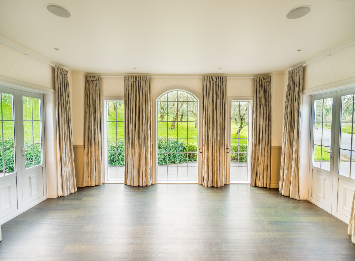 The elegant, Mediterranean-inspired interior event space at Bracu Estate, Auckland, features views of olive groves.