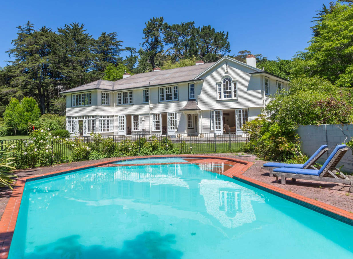 An inviting swimming pool and loungers beside the elegant, Hamptons-inspired historic homestead at Tipapa Estate, Canterbury.