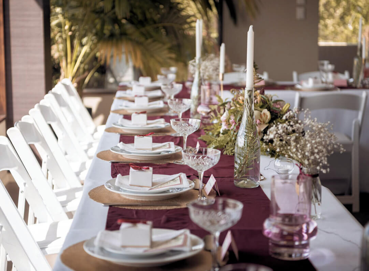 An elegant dining setup on the terrace of Waipuna Estate, Christchurch, showcasing its luxurious style and natural green surroundings.