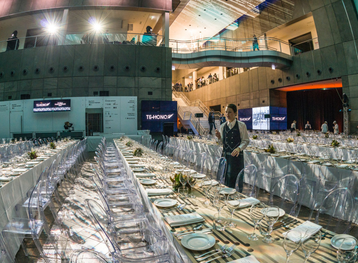 A modern, multi-level gala dinner setup in the dramatic glass foyer of Christchurch Art Gallery Te Puna o Waiwhetū, Christchurch.
