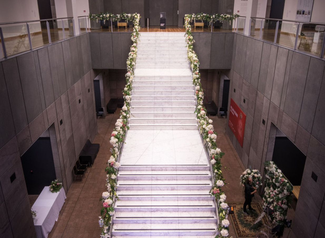 The modern Christchurch Art Gallery Te Puna o Waiwhetū's dramatic marble staircase is adorned with festive floral garlands.