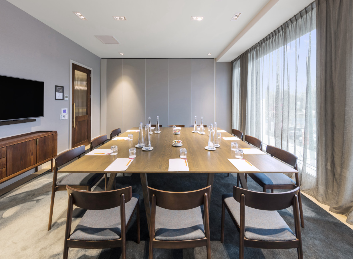 Crowne Plaza Christchurch's modern boardroom is set for a meeting, brightened by ample natural light.