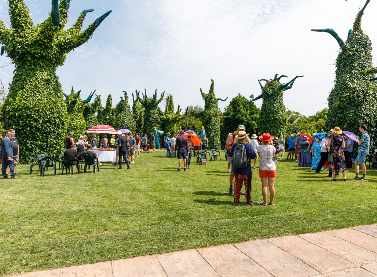 Guests enjoy an outdoor gathering amidst the distinctive surrealist topiary trees at Hamilton Gardens, Hamilton.