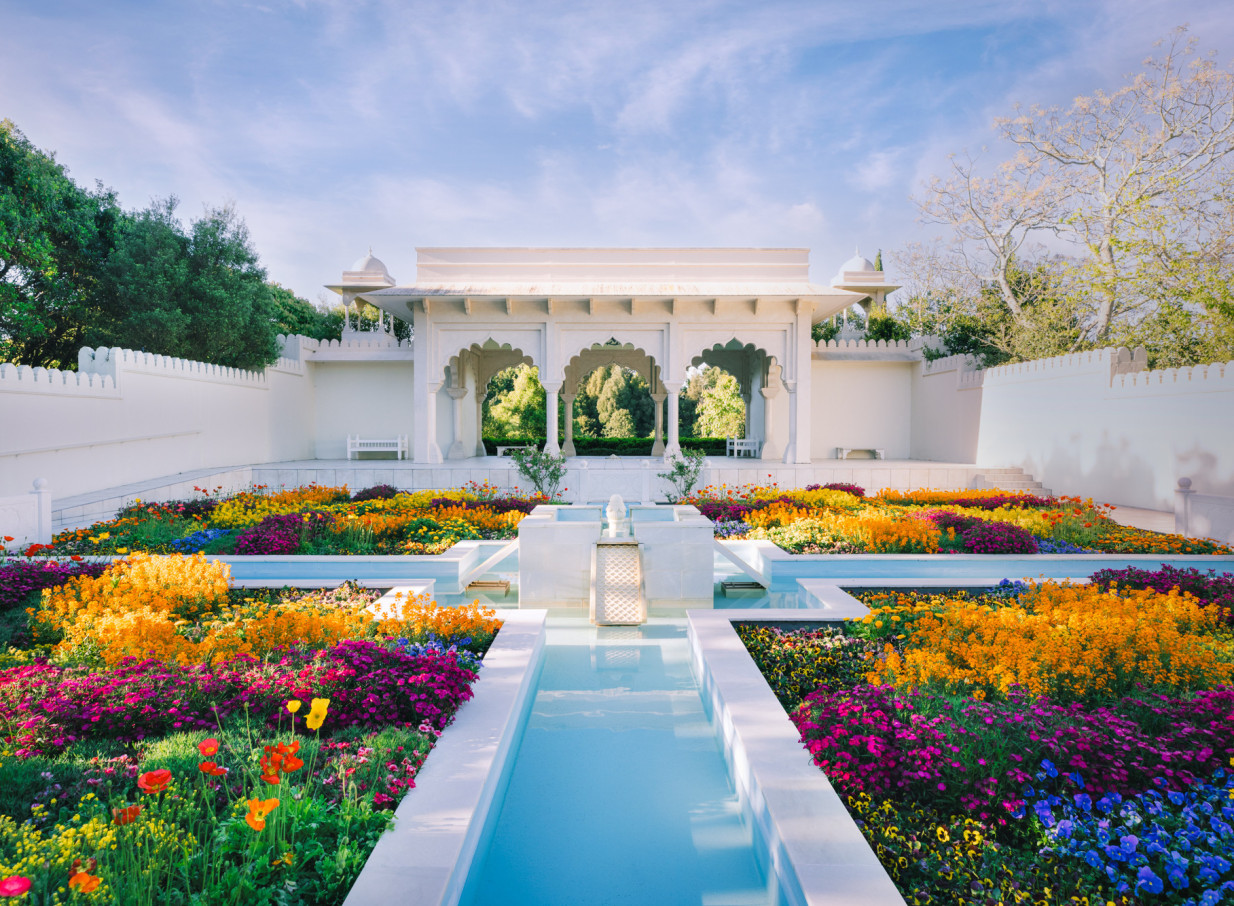 Hamilton Gardens' Mughal-inspired Indian Char Bagh Garden showcases vibrant flowers, water features, and a majestic white pavilion.