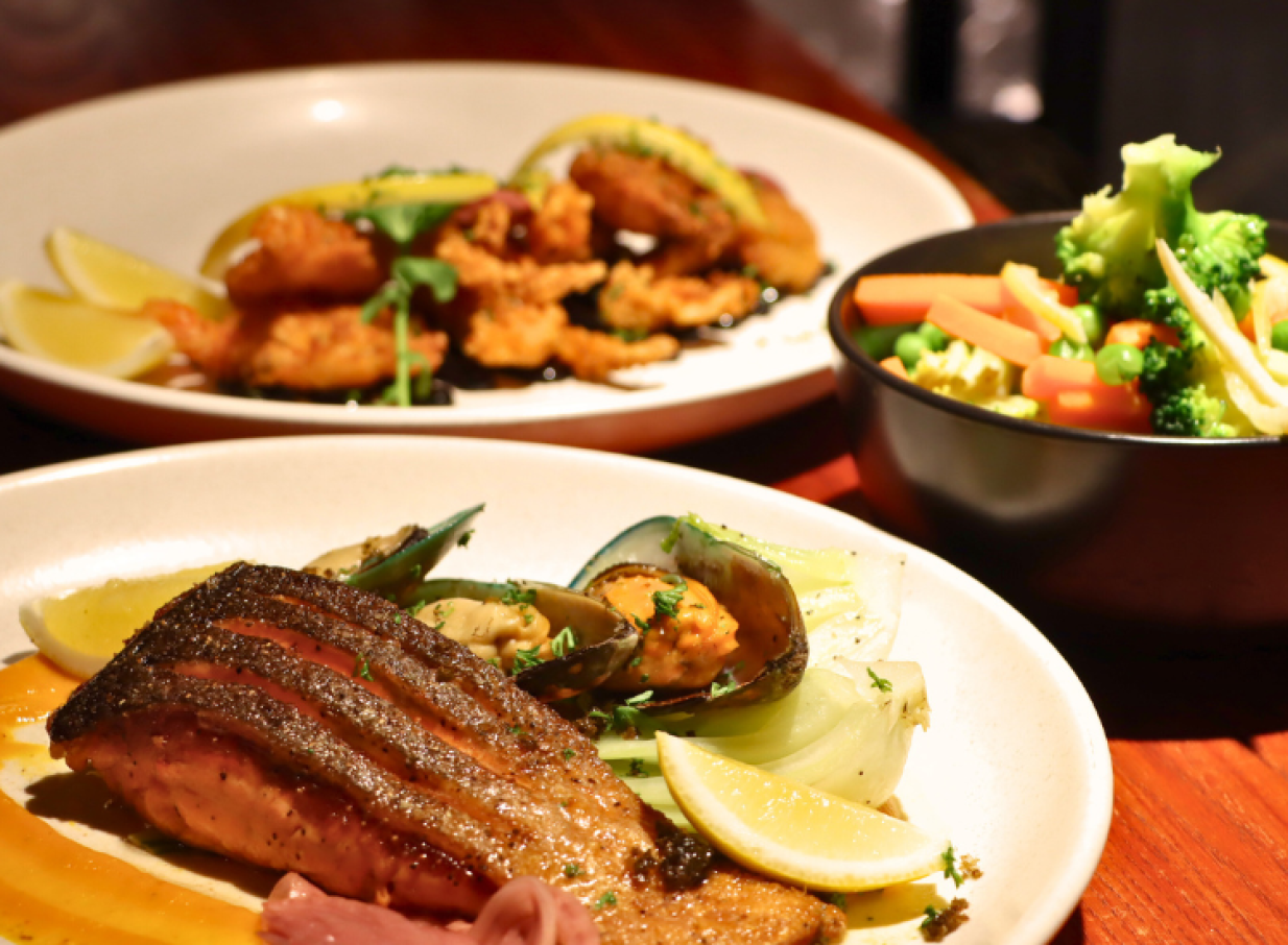 A modern Kiwi dining experience at JetPark Hamilton Hotel, featuring grilled salmon, mussels, and fried seafood.