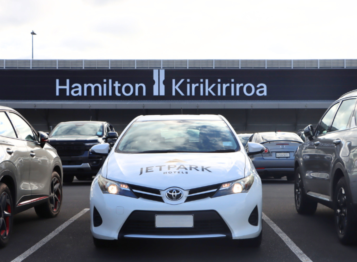 JetPark Hamilton Airport Hotel's modern car park, with a branded car and a large 'Hamilton Kirikiriroa' sign.