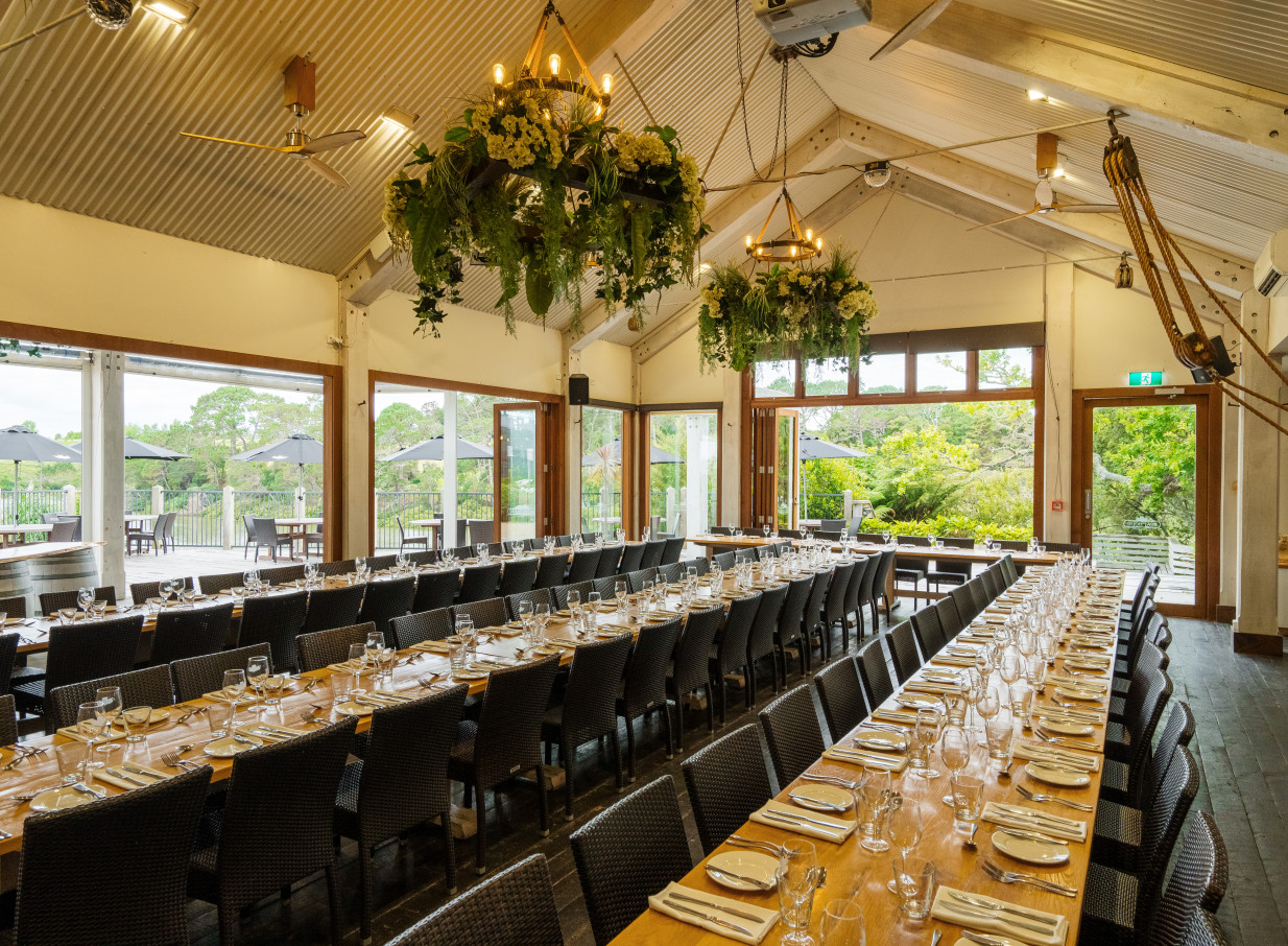 The Boat House Auckland's rustic boathouse-style dining room offers elegant banquet seating and outdoor views.