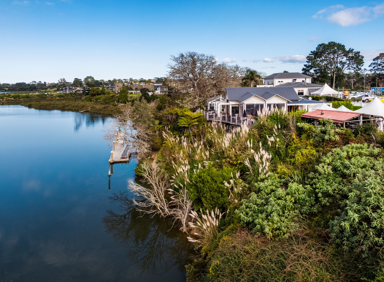 The Boat House in Auckland, an architecturally designed waterfront venue, features a spacious deck overlooking serene waters.