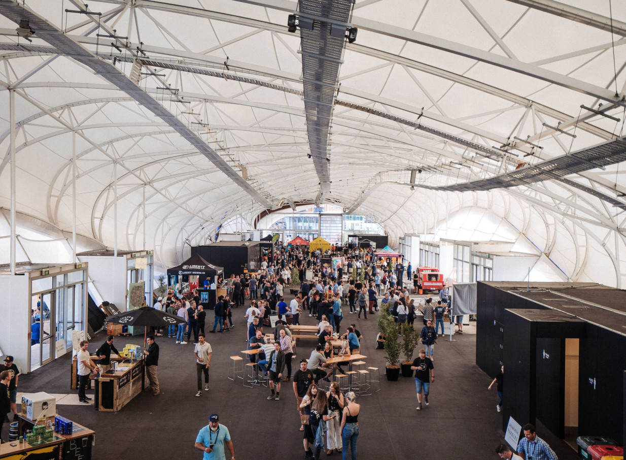 A bustling event fills the modern, fluid-form exhibition floor of The Cloud in Auckland.
