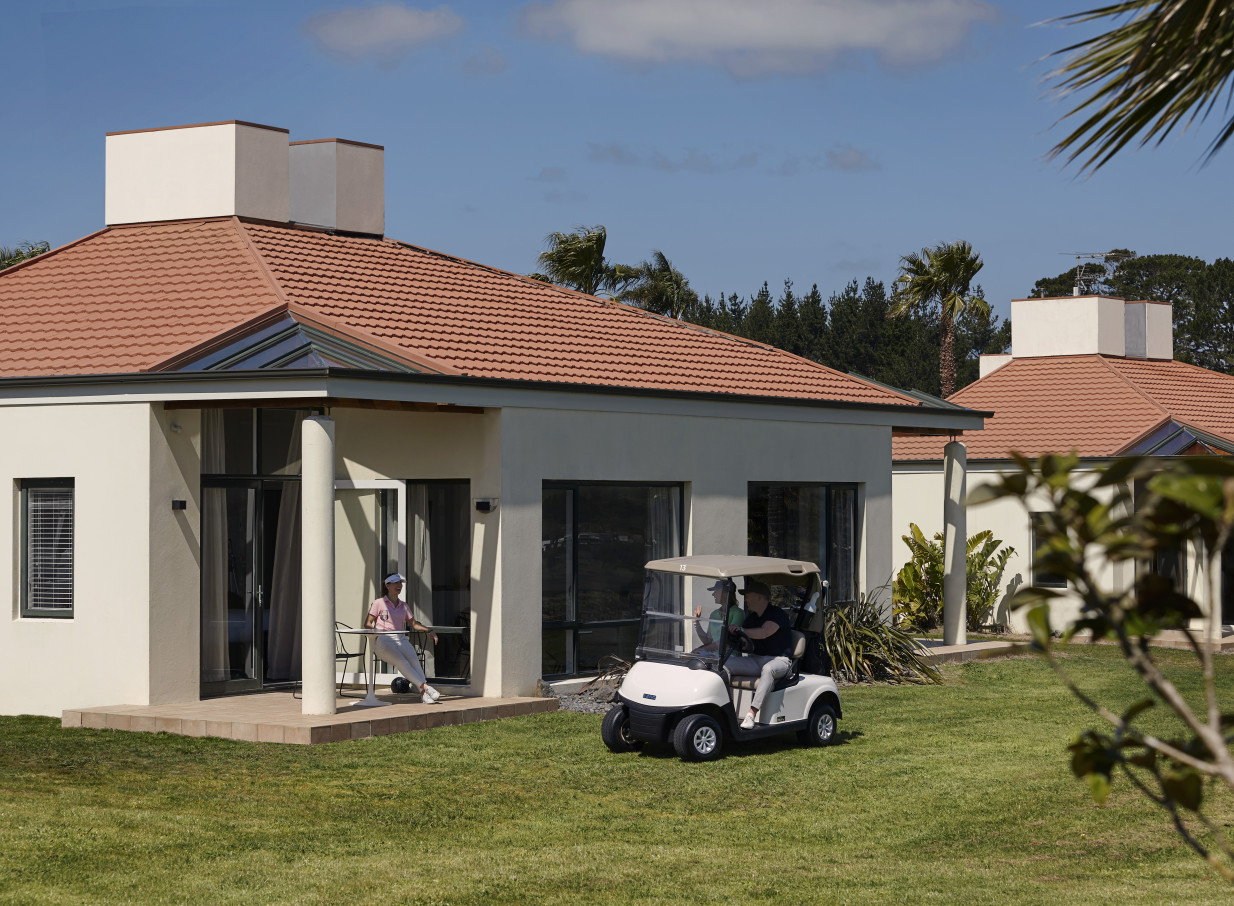 Guests enjoy a coastal resort-style villa with a patio and golf cart at Rydges Formosa Auckland Golf Resort.