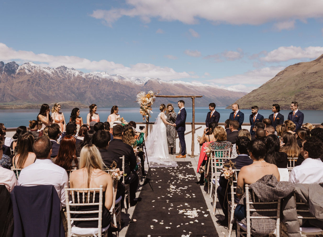 An outdoor ceremony at Rendezvous Heritage Hotel Queenstown, a modern alpine lodge with stunning lake and mountain views.
