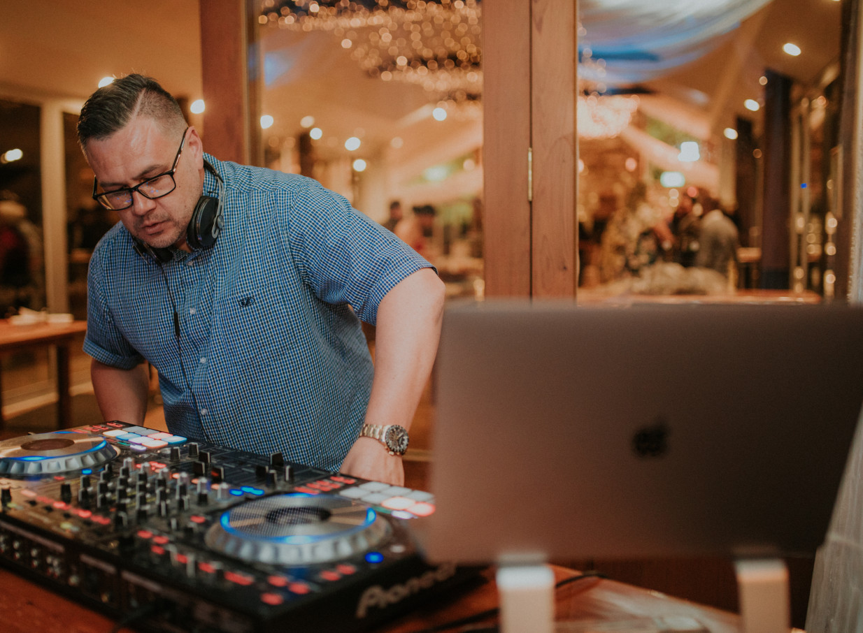 A DJ entertains guests in the light-filled, vine-adorned reception hall of Markovina Vineyard Estate, Auckland.