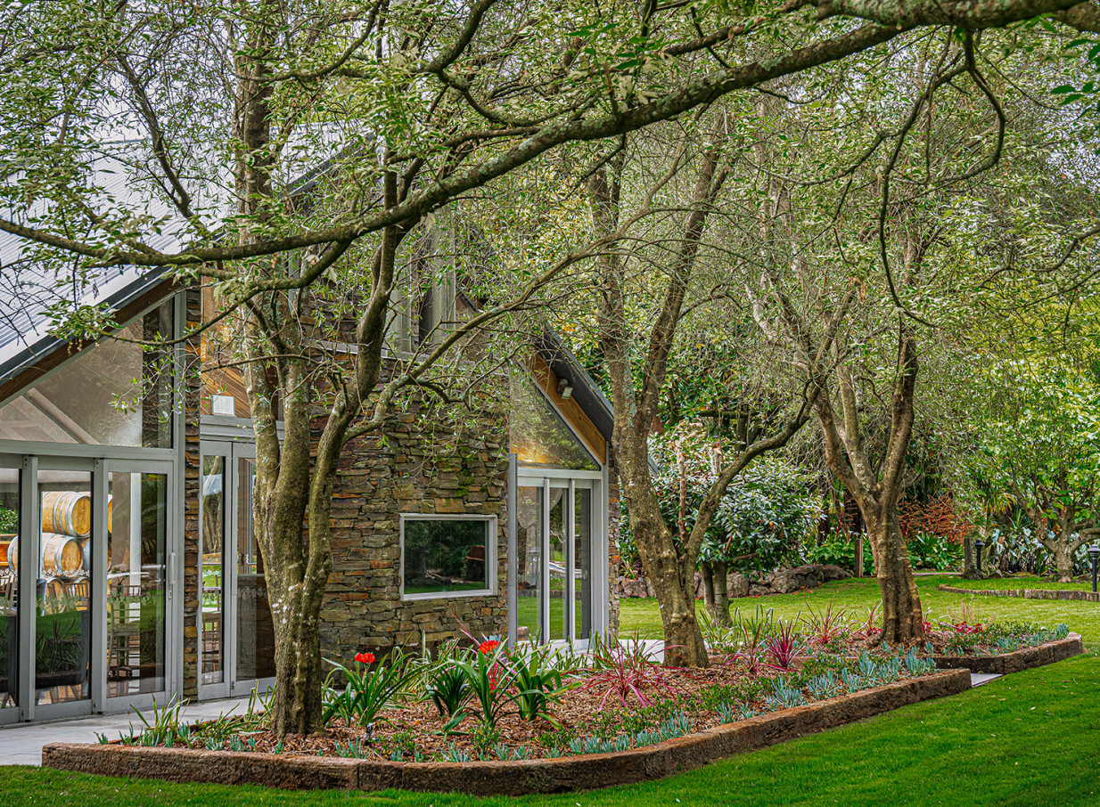 Markovina Vineyard Estate, Auckland, features a stone and glass event building beautifully integrated into its lush gardens.