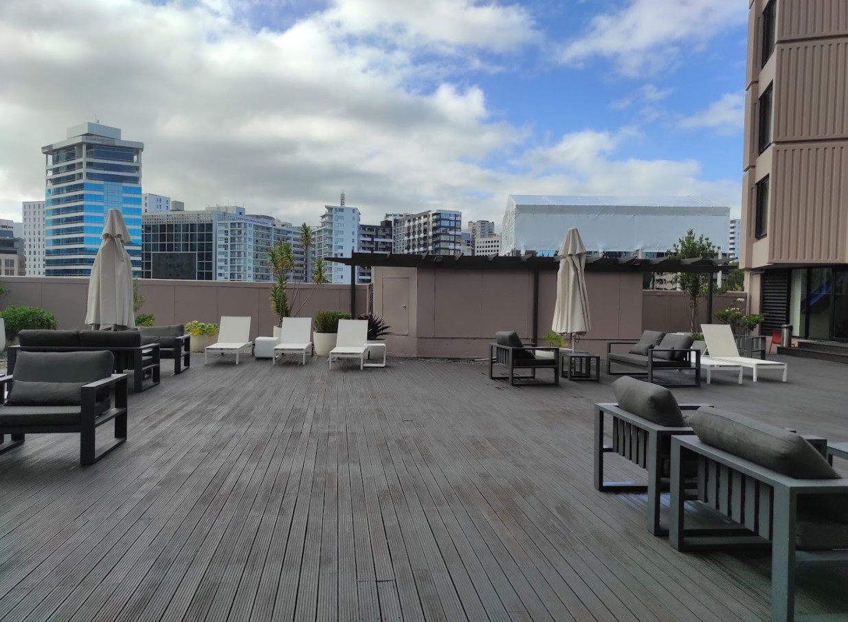 Grand Millennium Auckland's modern rooftop terrace features chic lounge seating and city views in the heart of urban Auckland.