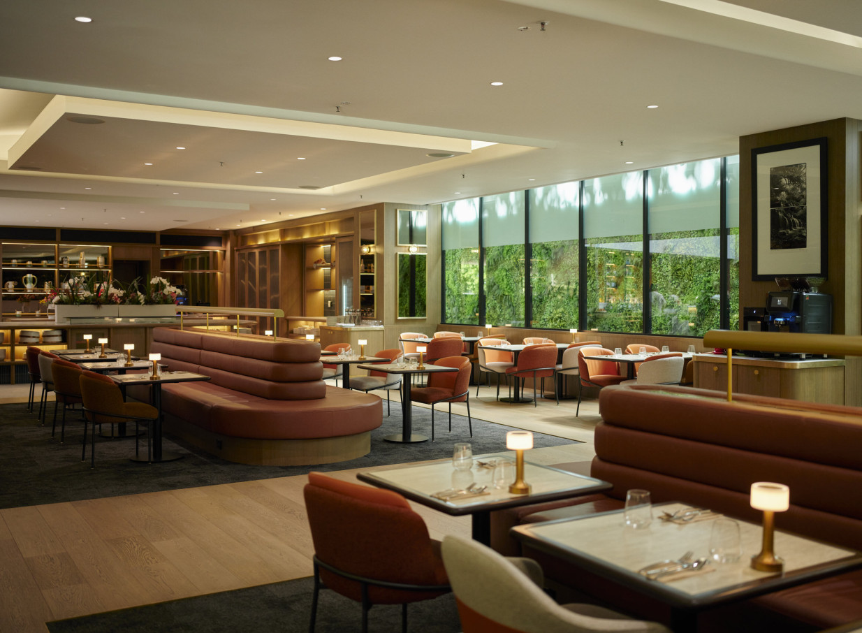 The chic, modern dining room at the Grand Millennium Auckland's Ember restaurant offers a relaxed atmosphere with a green wall view.
