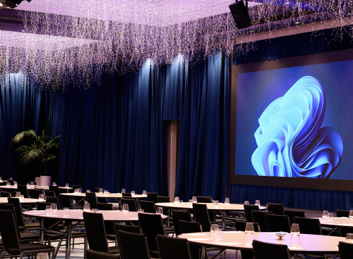 A conference setup at the Grand Millennium Auckland's ballroom, illuminated by its unique Sky Garden LED lighting sculpture.