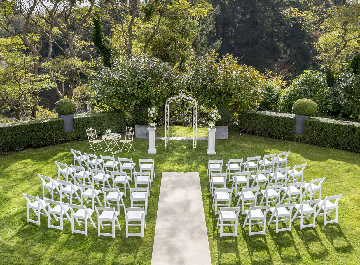 An outdoor ceremony setup in the Victorian-style manicured gardens of Hilton Lake Taupo, Taupo.