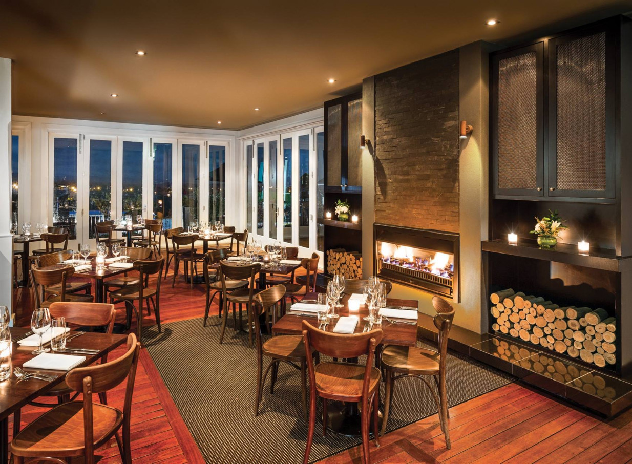 Bistro Lago at Hilton Lake Taupo, a Victorian-meets-modern dining room, offers a cozy fireplace and panoramic lake views.
