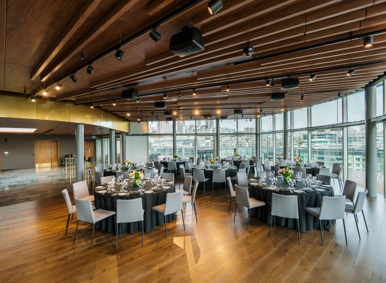 The elegant Harbour Room at Park Hyatt Auckland, a modern event space with warm timber and panoramic Viaduct Harbour views, is set for a banquet.