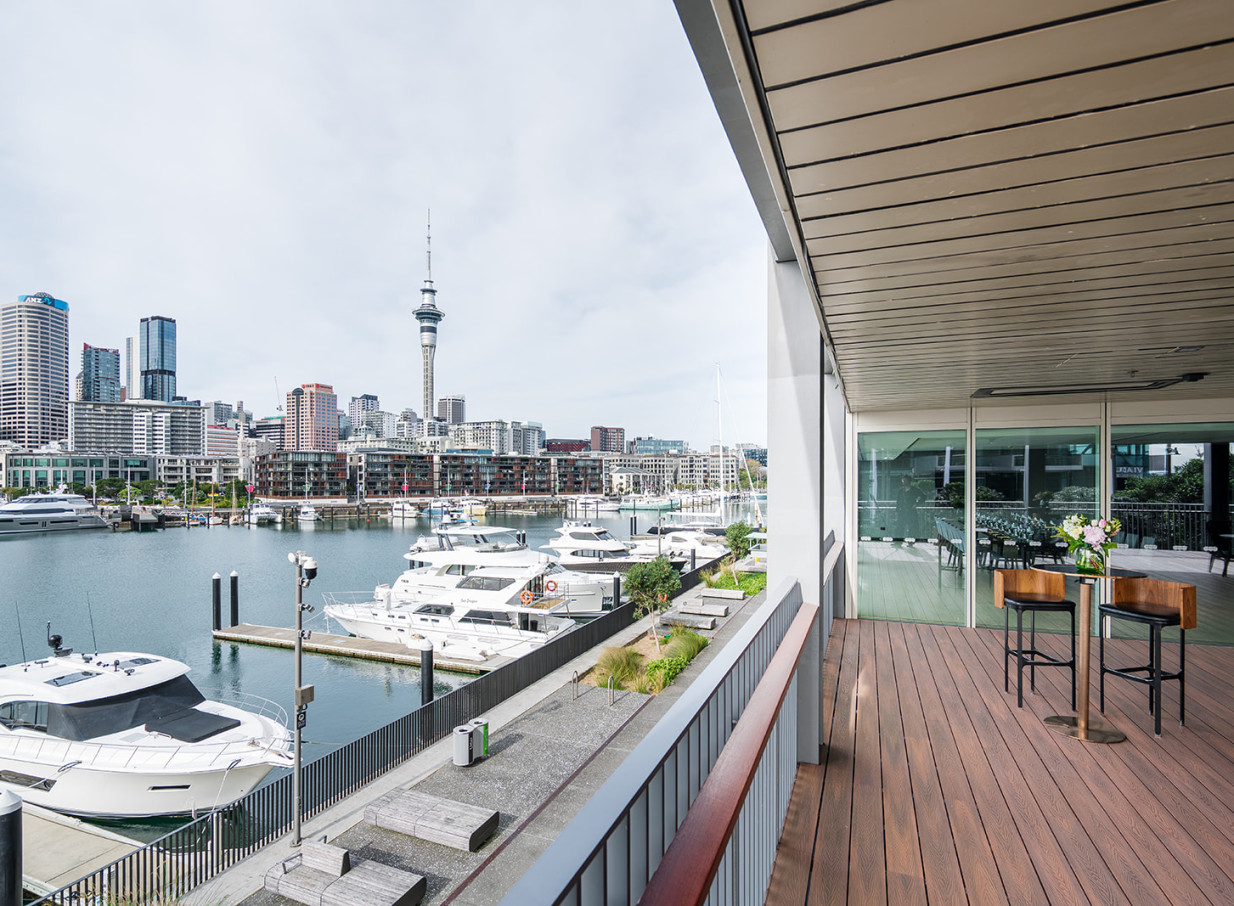 A modern outdoor terrace at Park Hyatt Auckland overlooks the marina and Auckland's vibrant city skyline.