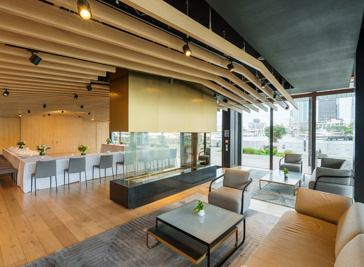 This image features a contemporary, nautical-inspired private dining and lounge area with waterfront views at Park Hyatt Auckland.