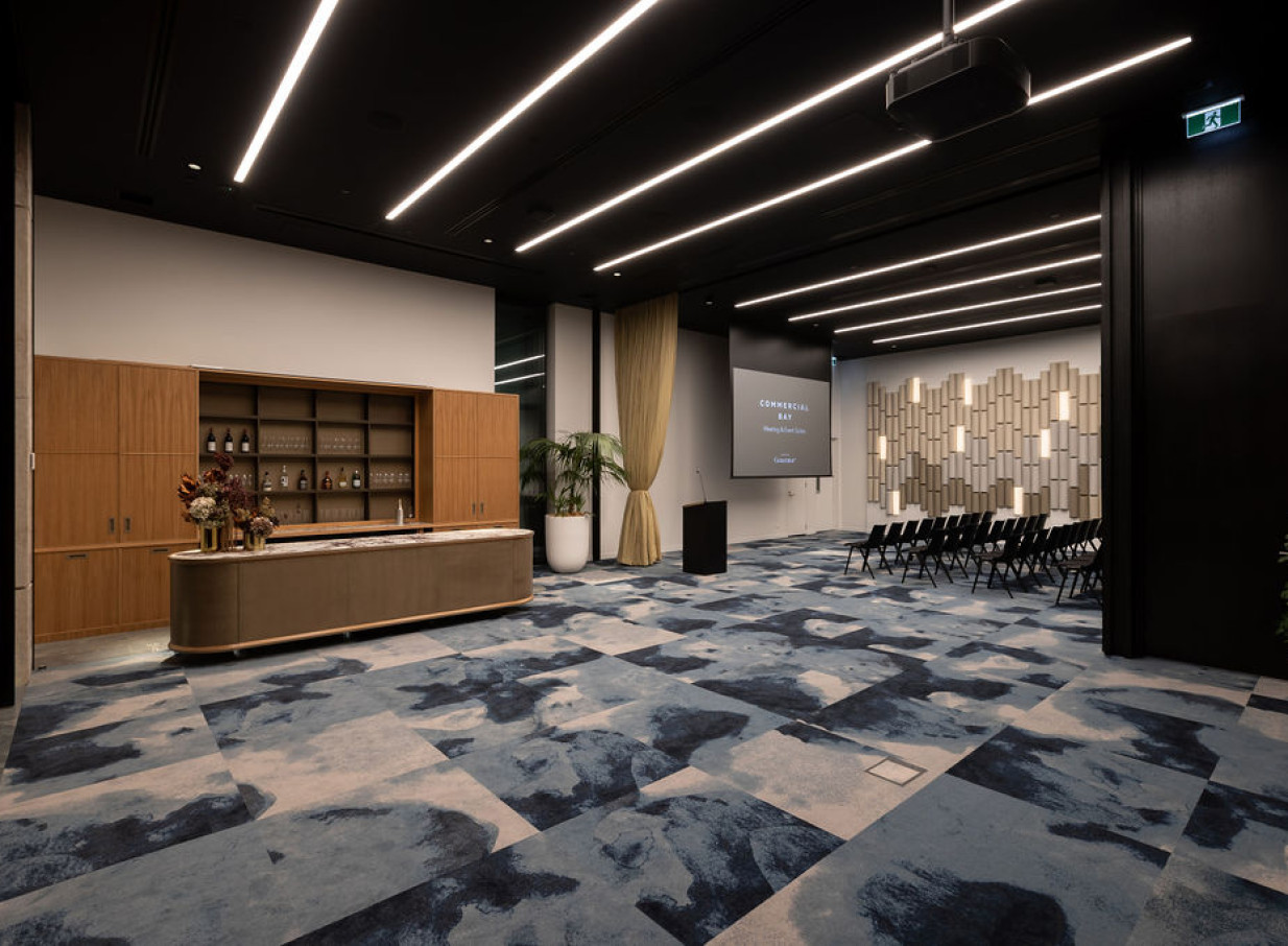 A sophisticated, modern event space at Commercial Bay, Auckland, with a bespoke timber bar and acoustic wall design.