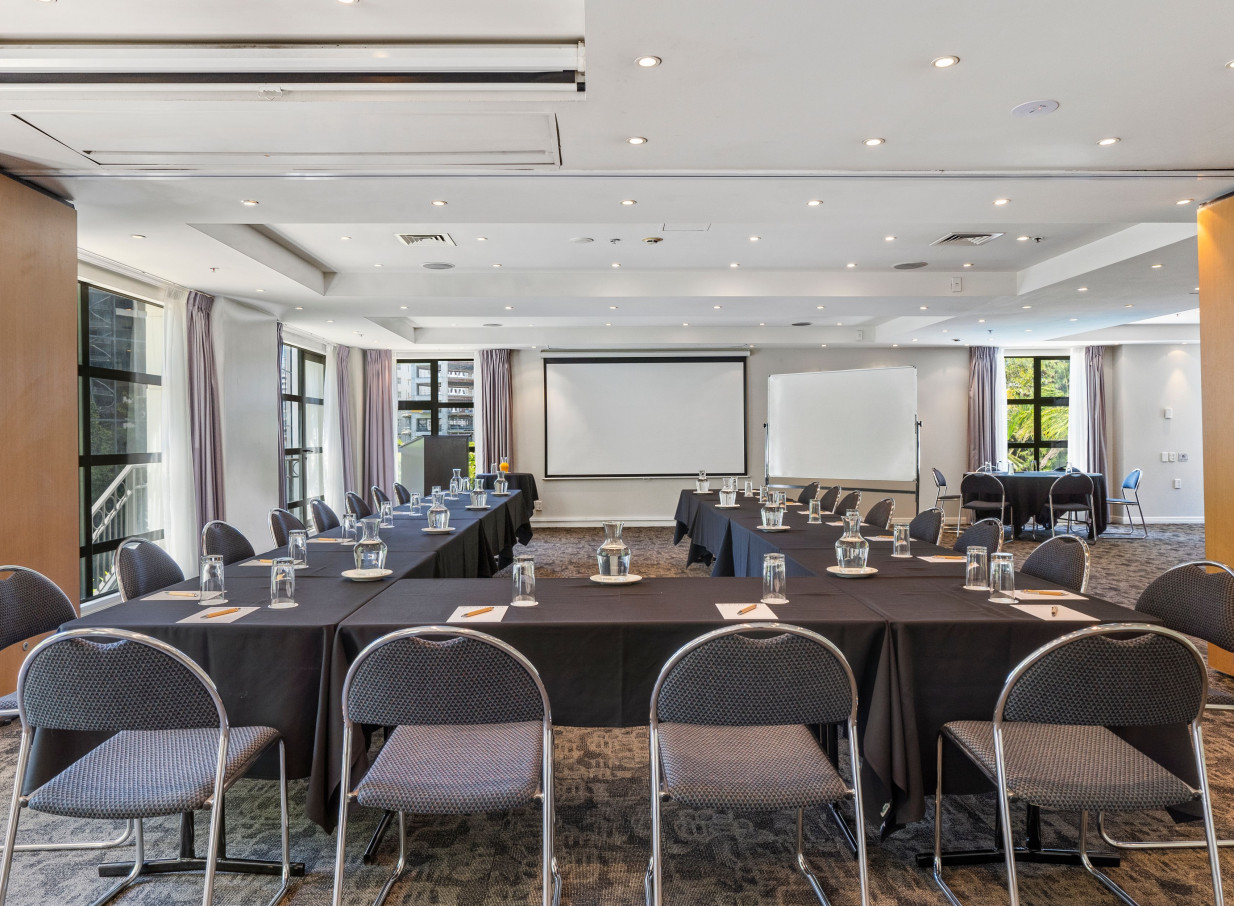 A contemporary U-shaped meeting room at Parkside Hotel and Apartments Auckland, featuring natural light and functional decor.